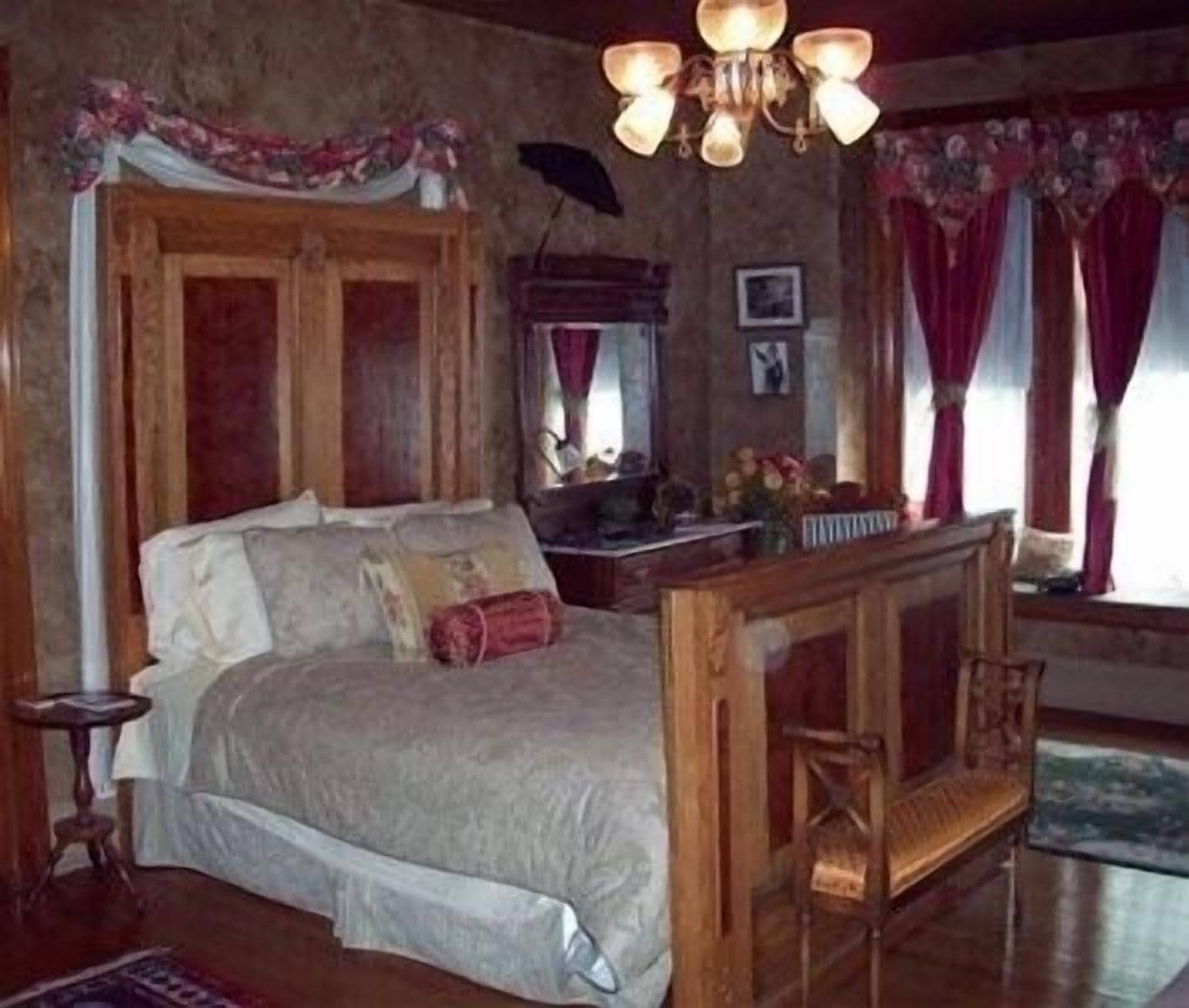 Una camera da letto con un letto di legno, un comodino e un lampadario.