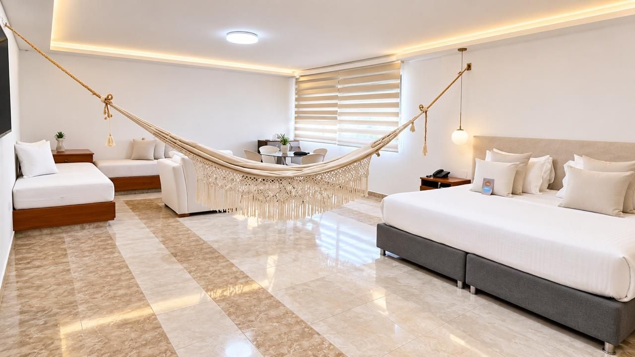 Una habitación de hotel moderna con una hamaca, un sofá, una cama y un comedor.