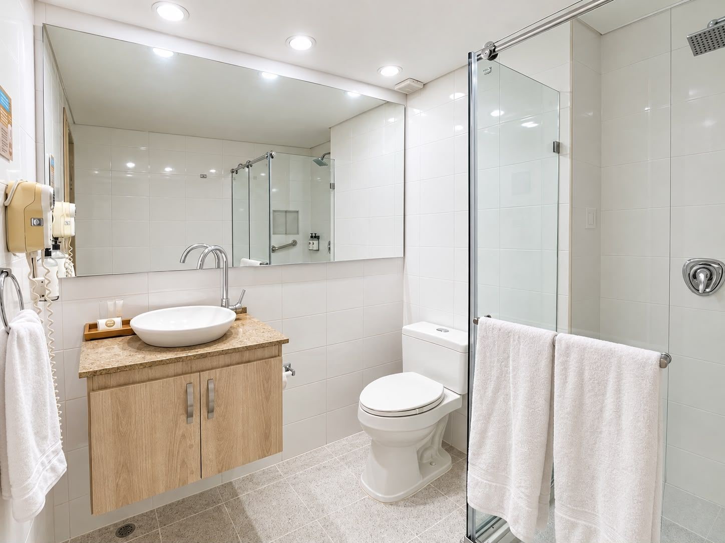 A modern bathroom with a glass shower enclosure, a white sink, and a toilet.