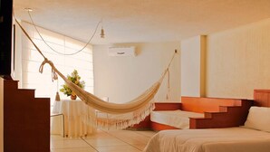 A room with a hammock, a bed, a small table with a plant, and a staircase. - Hotel Sicarare (Valledupar)