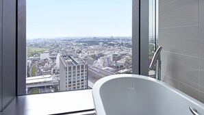 A modern bathroom with a freestanding bathtub, large windows offering a city view. - FutakoTamagawa Excel Hotel Tokyu (Tokyo)