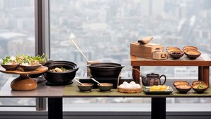 A table with various dishes and cooking utensils, set against a cityscape view. - FutakoTamagawa Excel Hotel Tokyu (Tokyo)
