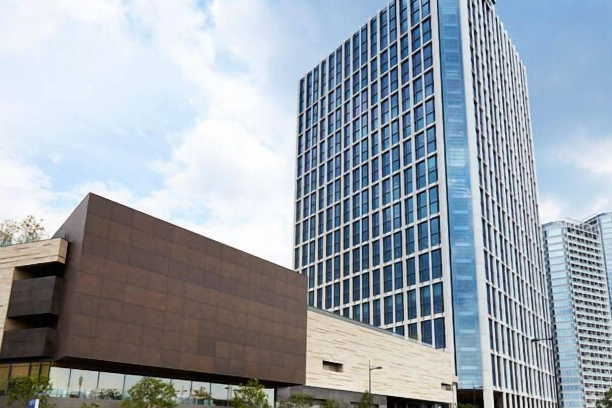 A modern building with a glass facade and a flat roof.