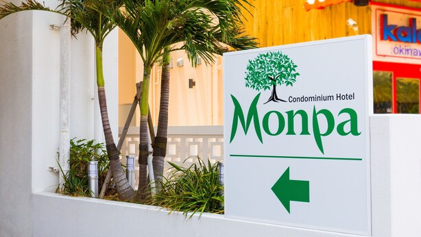 A sign for the Monpa Condominium Hotel with a directional arrow. - Condominium Hotel Monpa (Chatan)