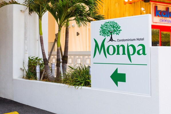 A sign for the Monpa Condominium Hotel with a directional arrow. - Condominium Hotel Monpa (Chatan)