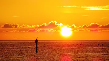 Un atardecer sobre el océano, con una boya al frente.