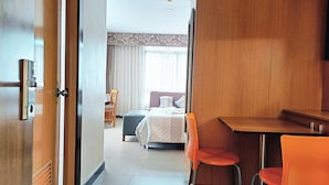 Une chambre d’hôtel avec un lit, un bureau et deux chaises.