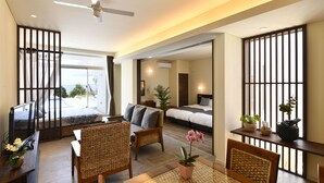 Una habitación de hotel moderna con balcón, un sofá, una mesa de comedor y una cama.