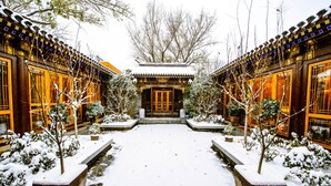 A traditional building with a symmetrical design, featuring a central entrance and two wings. - Cours Et Pavillons (Beijing)