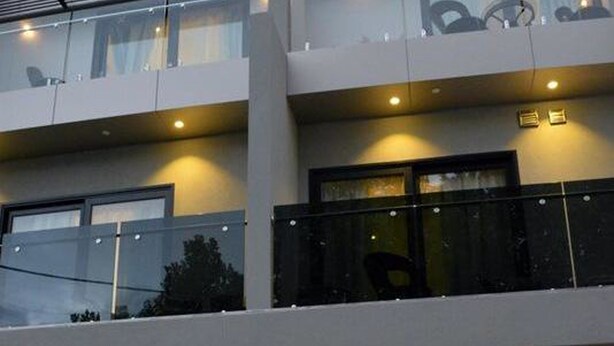 A multi-story building with balconies, windows, and a security fence. - Melrose Apartments (North Melbourne)