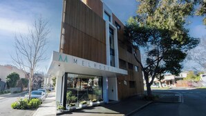 Un edificio moderno con un cartel que dice 'MELROSE APARTMENTS'.