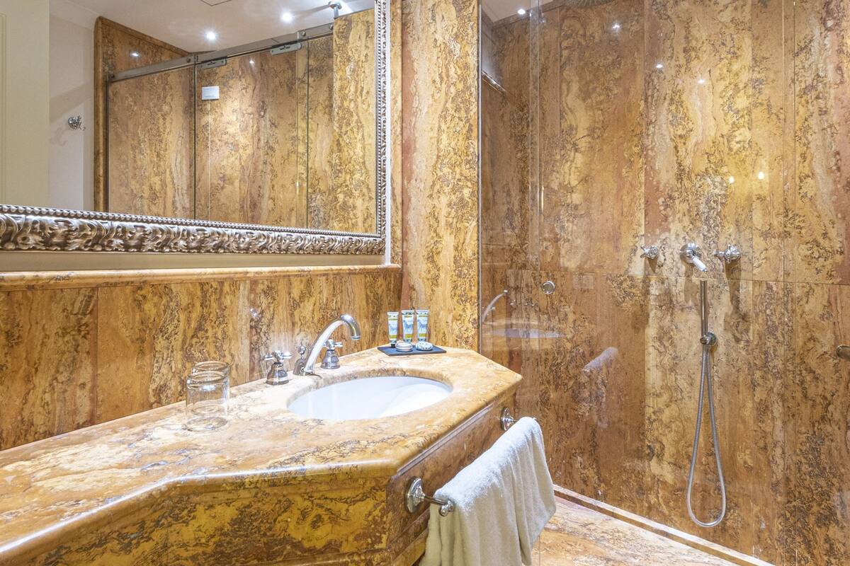 deluxe room | bathroom | shower, rainfall showerhead, hair dryer, slippers
