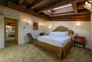 Una camera da letto con un letto grande, una sedia, un tavolino e una lampada.