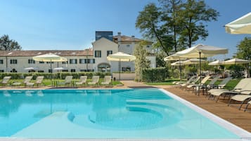 Una piscina al aire libre de temporada, sombrillas, tumbonas