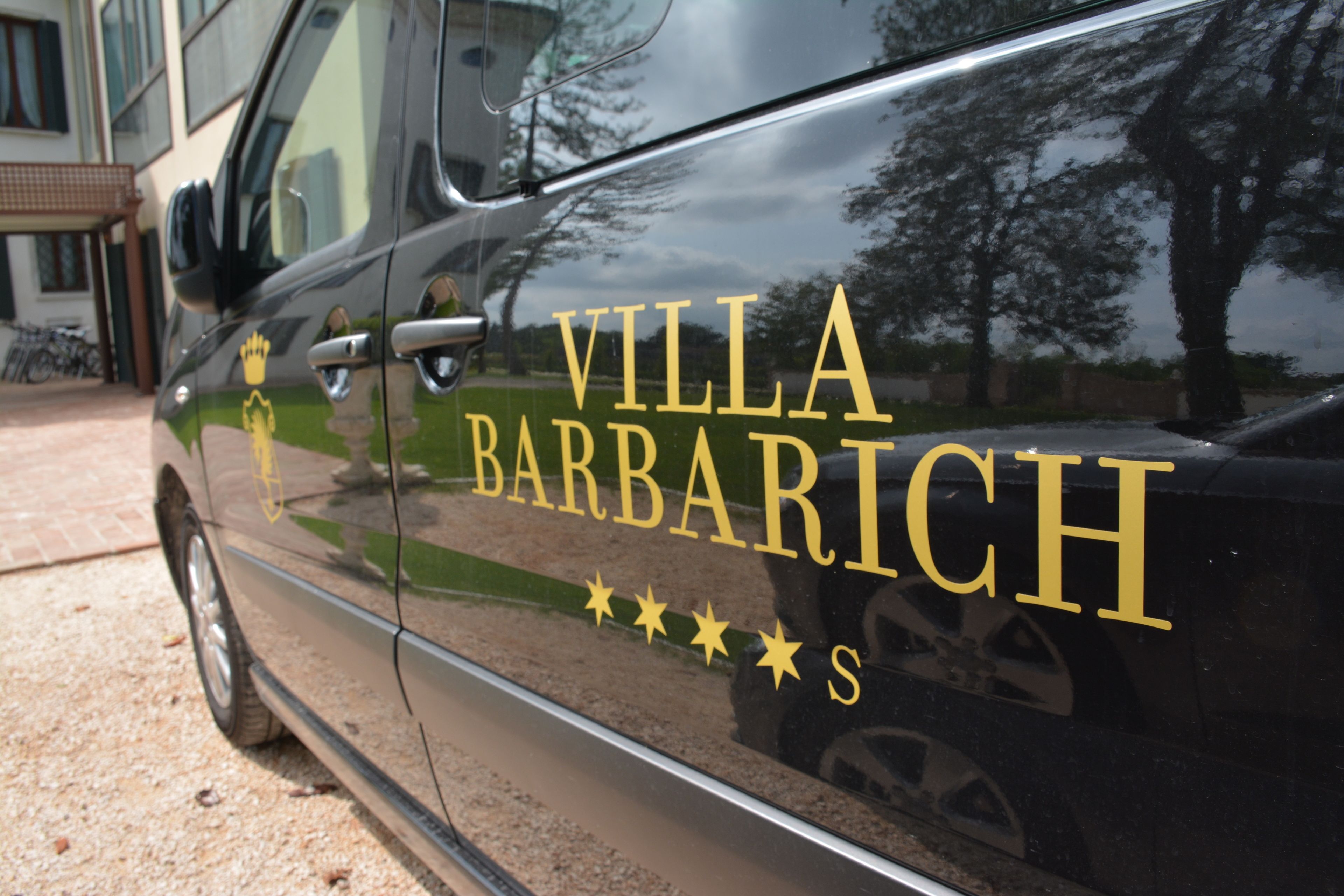 A black car with "VILLA BARBARICH" and a crown logo.