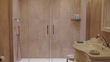 Un bagno moderno con doccia a filo pavimento, un water e un mobile lavabo con lavandino e specchio.
