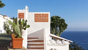 Un edificio blanco con un letrero que dice "Paradise Relais Villa Janto" y un letrero de "Coffee & Chill".