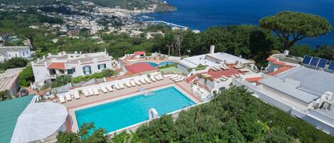Una piscina techada, una piscina al aire libre de temporada, sombrillas