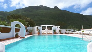 Una piscina techada, una piscina al aire libre de temporada, sombrillas