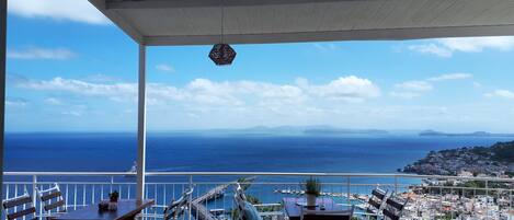 A terrace with a view of the sea and a coastal town.