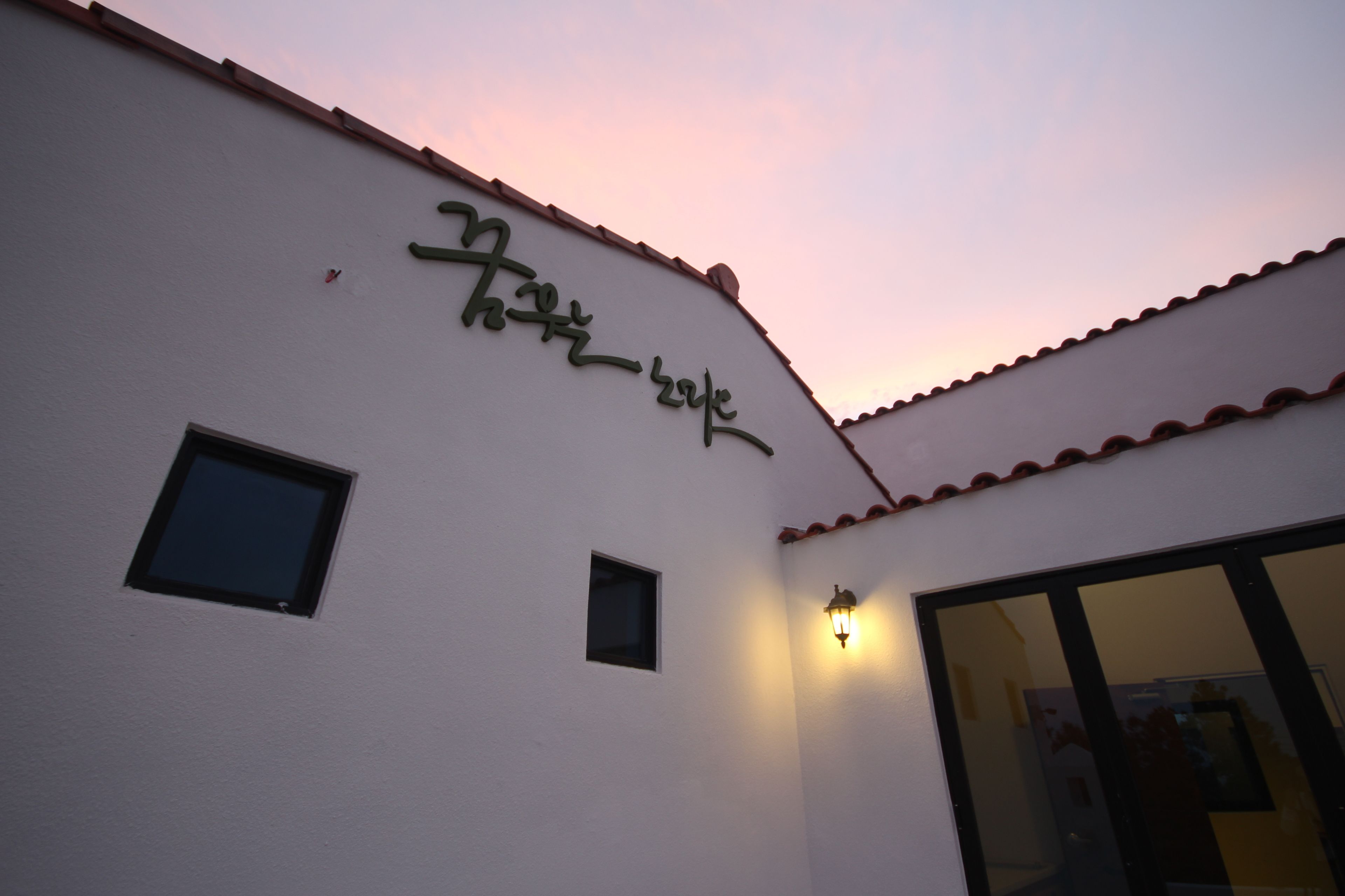 A building with a sign that reads "Hotel de Luxe" and a small window.