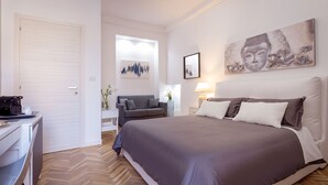 Un dormitorio con una cama grande, un escritorio, una silla y un sofá.