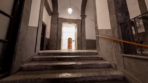 Una escalera de piedra que lleva a una puerta al final.