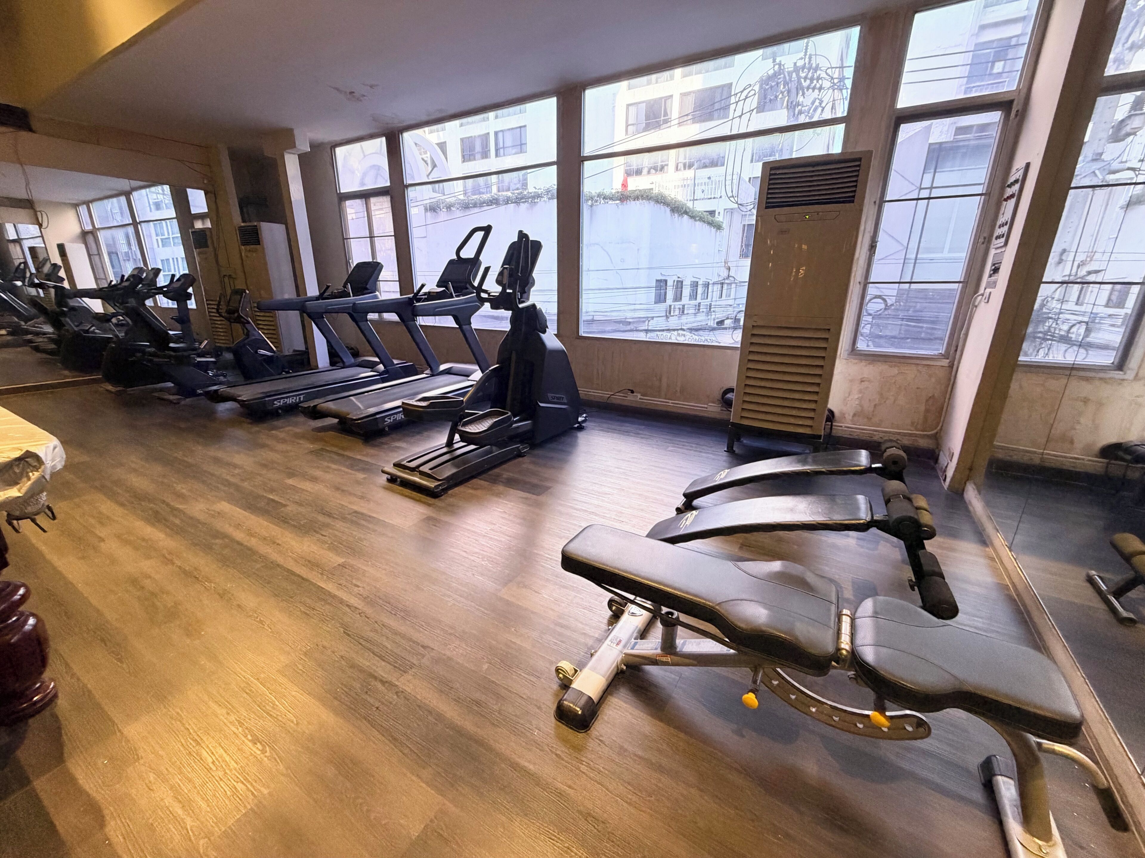 Un gimnasio con cintas de correr, bicicletas estáticas y máquinas de pesas.