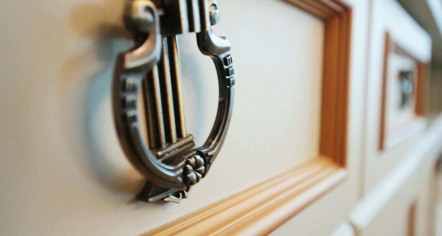 A close-up of a door handle with a decorative design.