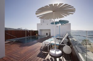Una piscina al aire libre, sombrillas, tumbonas