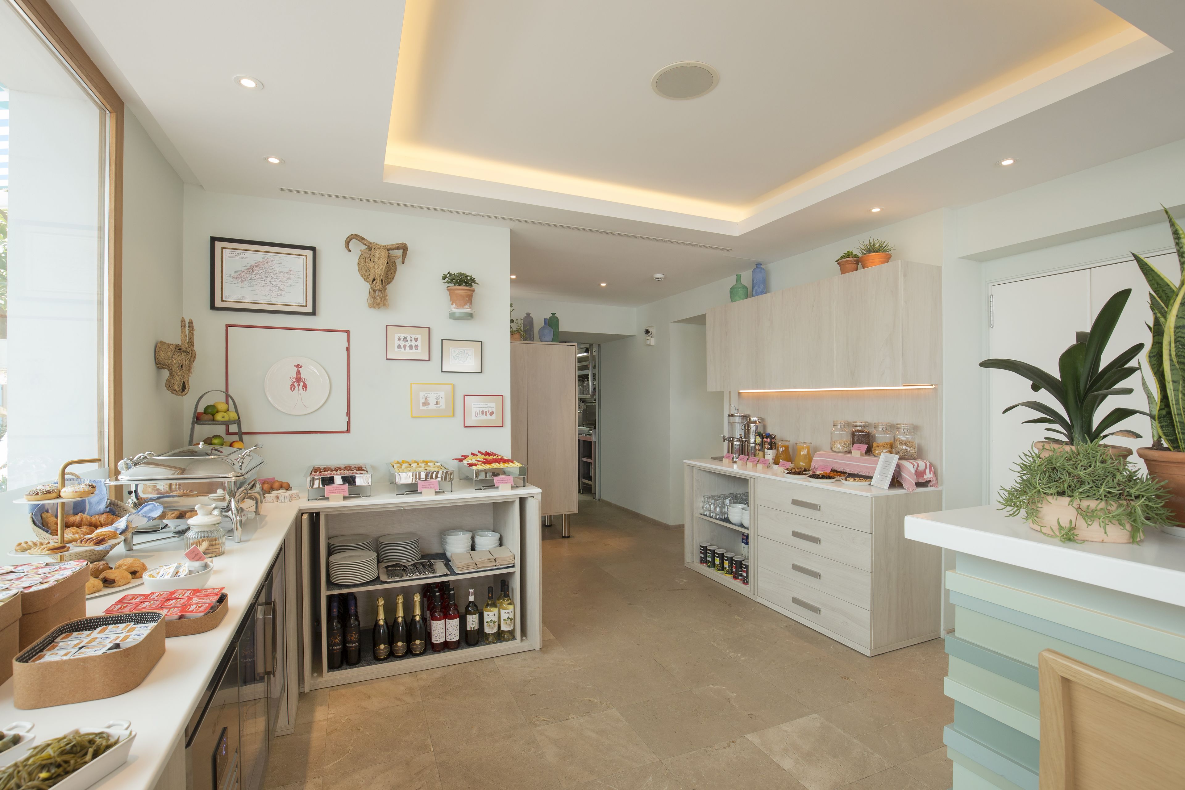 A well-lit kitchen with a buffet setup, various food items, and a wine selection.