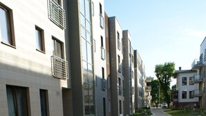 Un chemin pavé bordé de bâtiments modernes dotés de grandes fenêtres et de balcons.