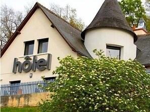 A hotel with a classic architectural style, featuring a prominent tower and a sign that reads "hotel".