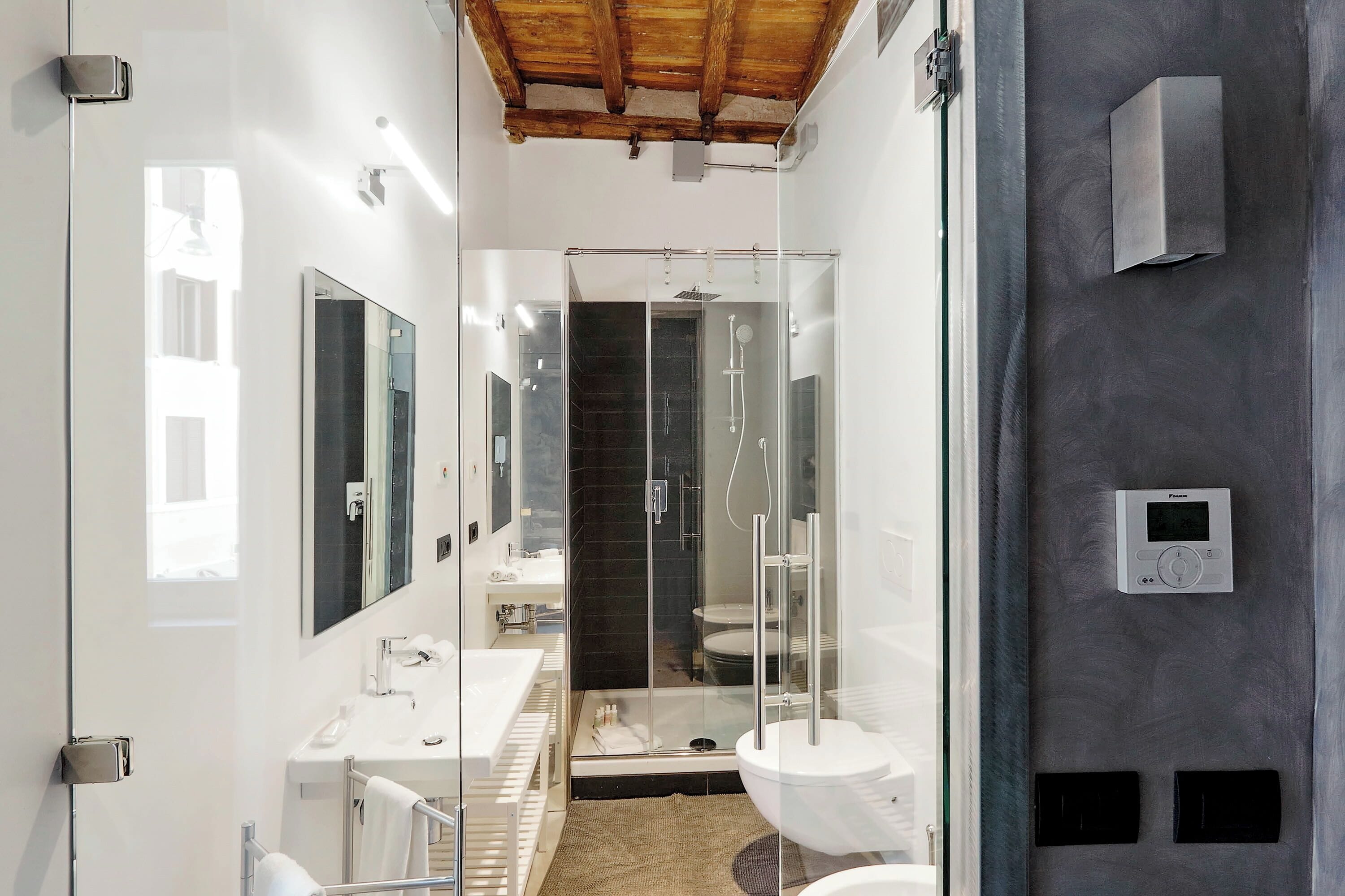 Ein modernes Badezimmer mit einer Glasdusche, einem weißen Waschbecken und einer Toilette.