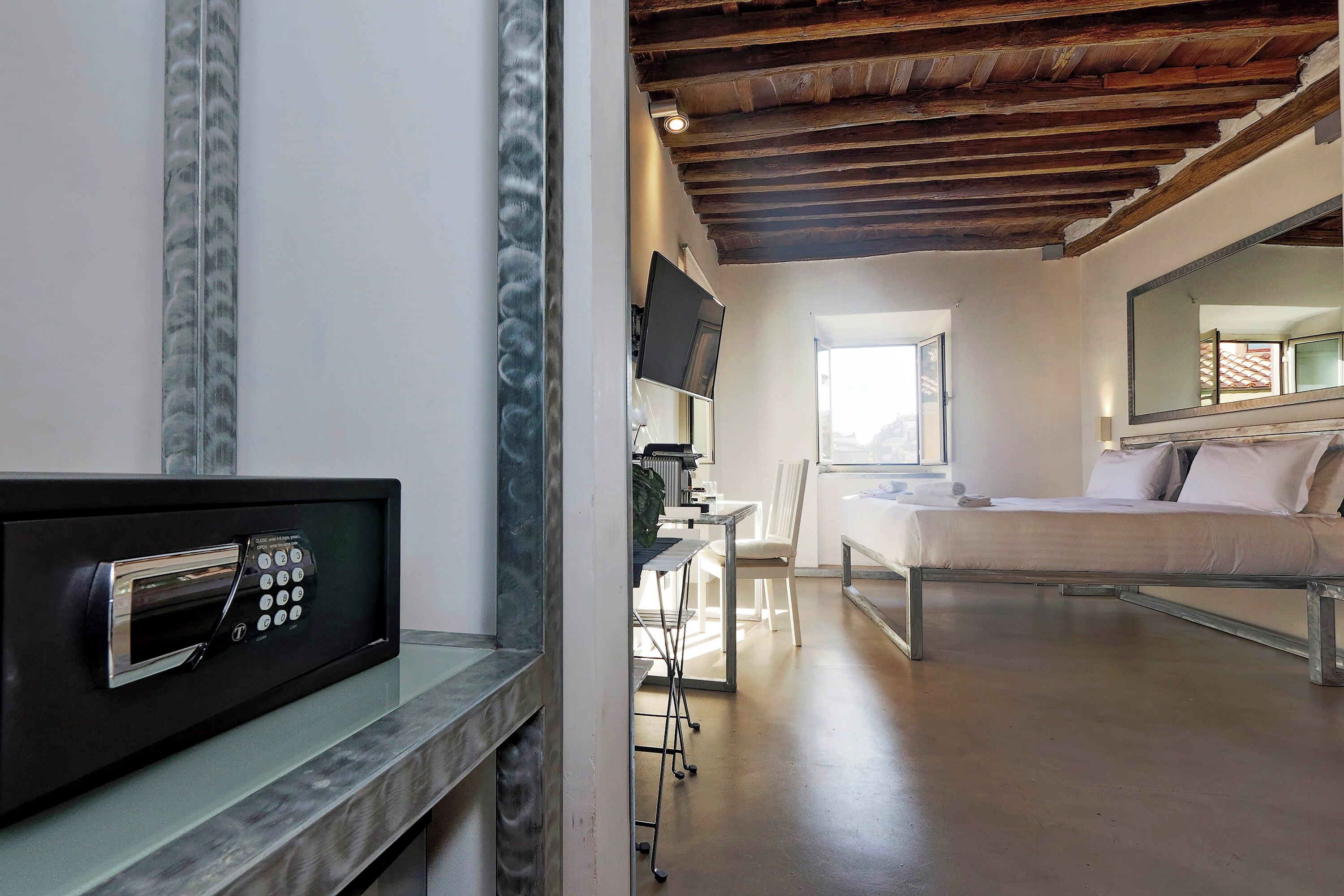 A modern hotel room with a bed, a desk, and a TV.