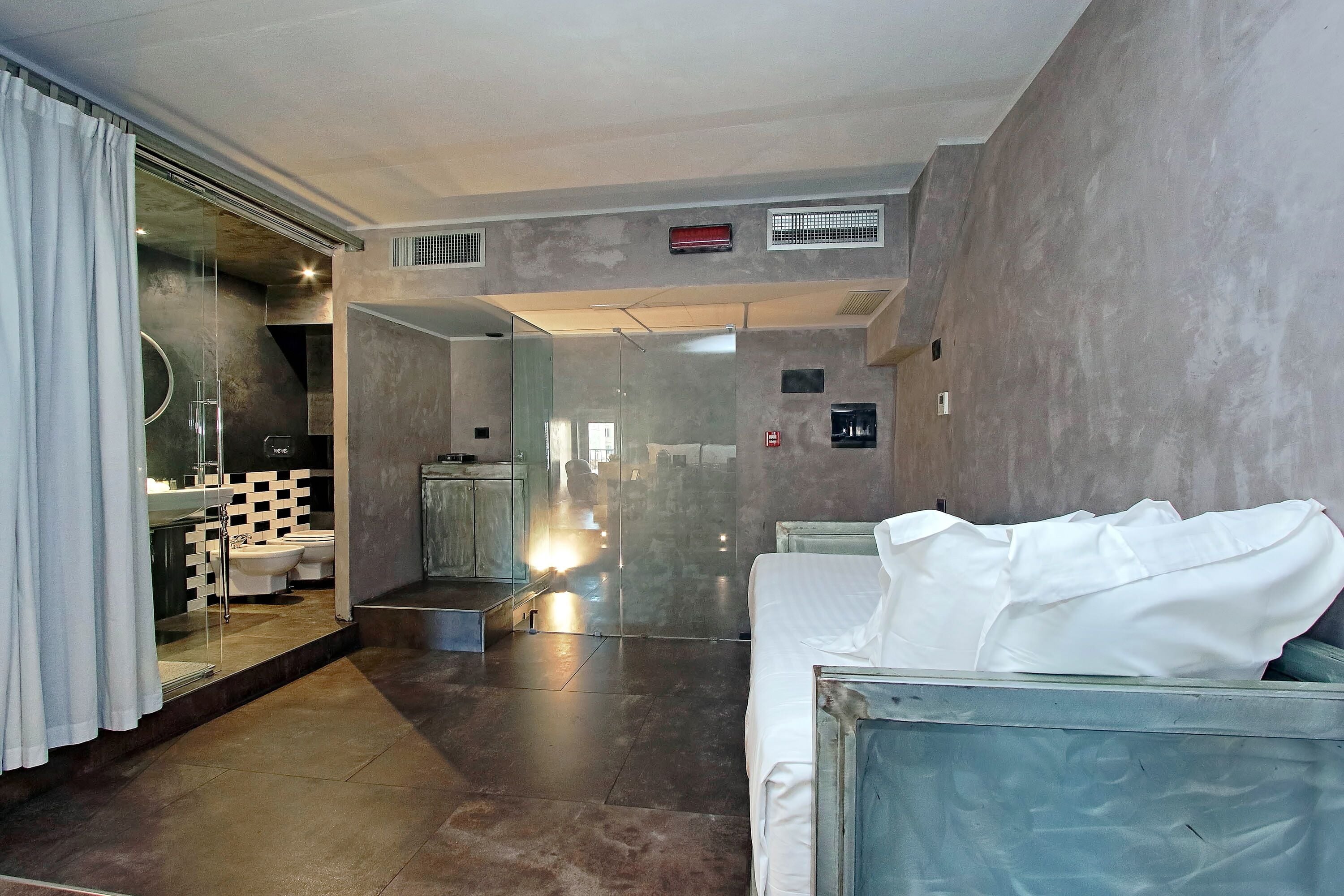 A modern bathroom with a glass shower enclosure, a white bathtub, and a visible toilet.
