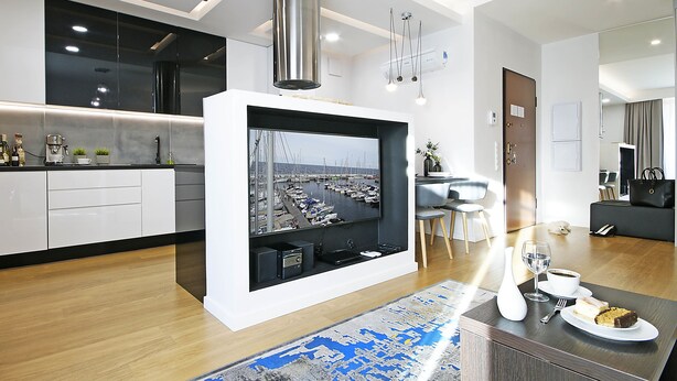 A modern kitchen with a large island, a dining area with a view, and a living space with a sofa and a coffee table. - IRS ROYAL APARTMENTS - IRS Neptun Park (Gdansk)