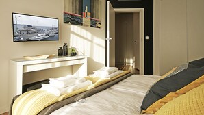 A hotel room with a bed, a desk, a television, and a door leading to another room. - IRS ROYAL APARTMENTS - IRS Neptun Park (Gdansk)