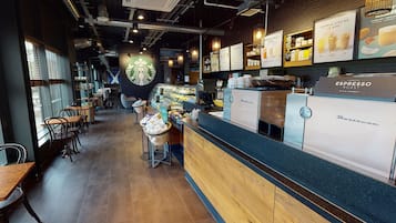 A Starbucks coffee shop interior with a counter, seating area, and menu boards.