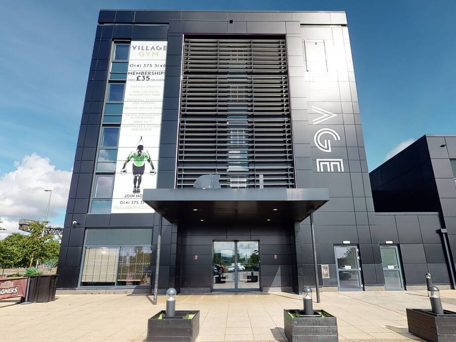 A modern building with a large sign advertising a gym.