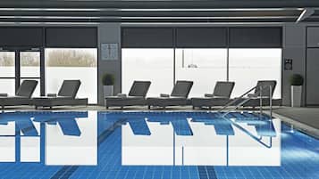 A swimming pool with lounge chairs and a view of the sky.