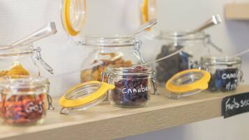 A shelf with multiple glass jars containing various dried fruits, each labeled with its contents.
