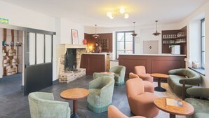 Un'area lounge moderna con posti a sedere, un camino e un bar.