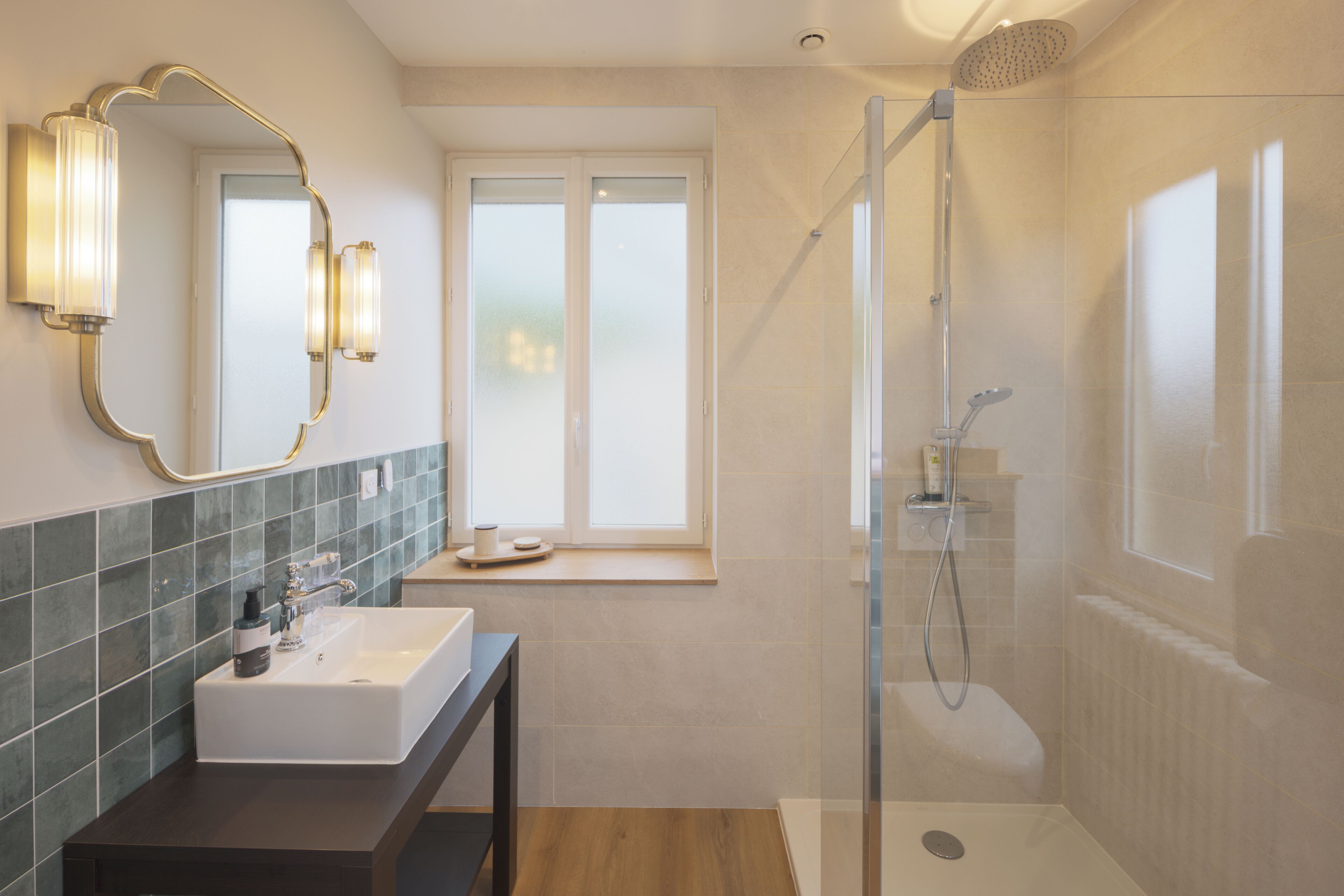 Une salle de bain avec une douche, un lavabo, un miroir et une fenêtre.
