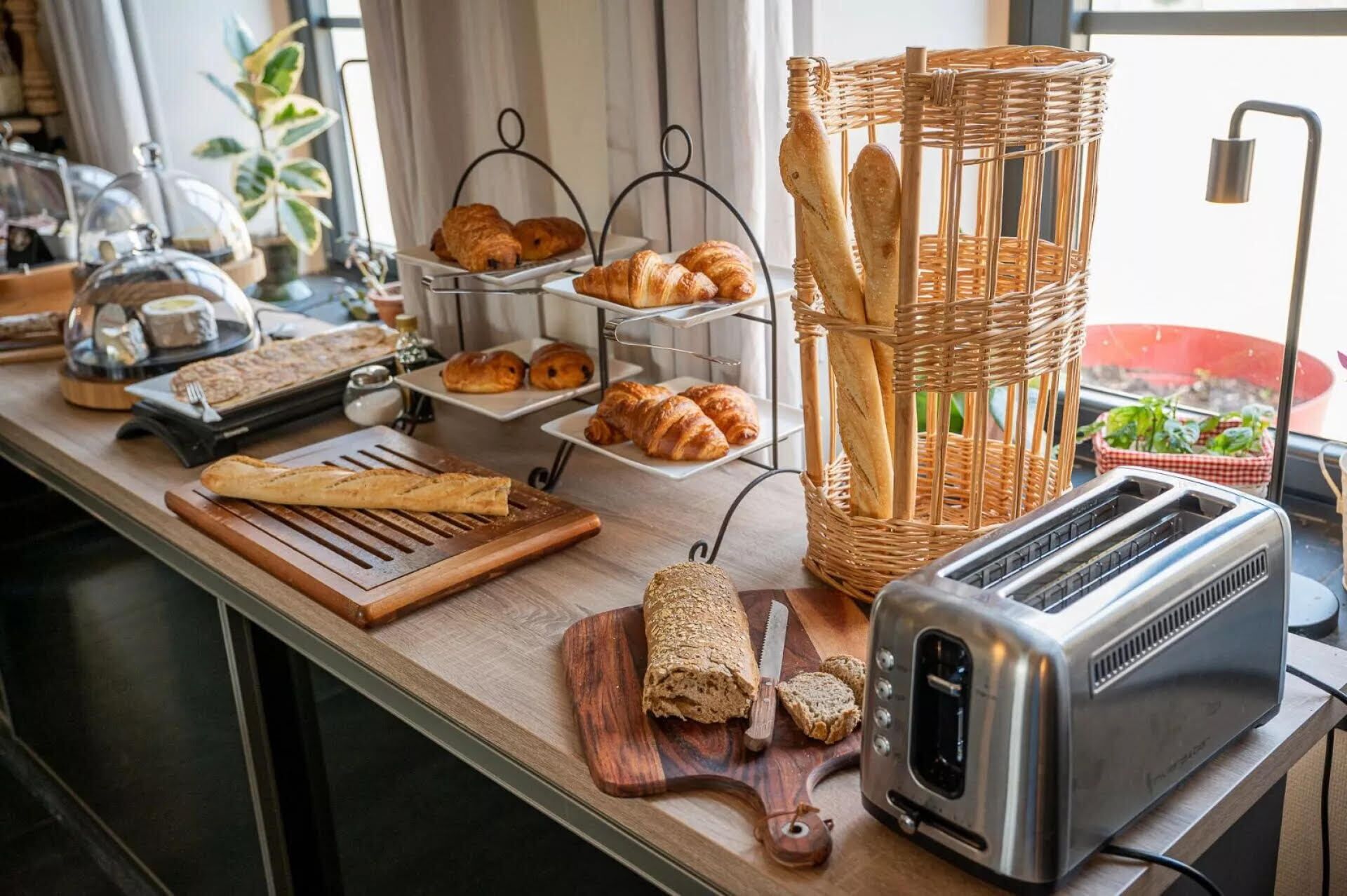 En köksbänk med bröd, croissanter, en brödrost och en brödkorg.