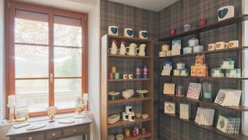 A room with a window, a desk with decorative items, and shelves with various storage boxes and containers.