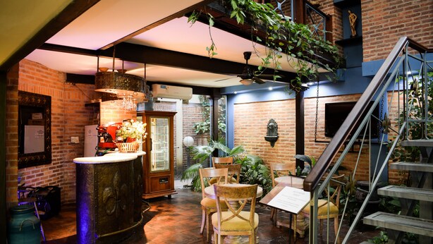 A cozy restaurant with brick walls, wooden furniture, and hanging plants. - Casa Grande Apart Hotel (Formosa)