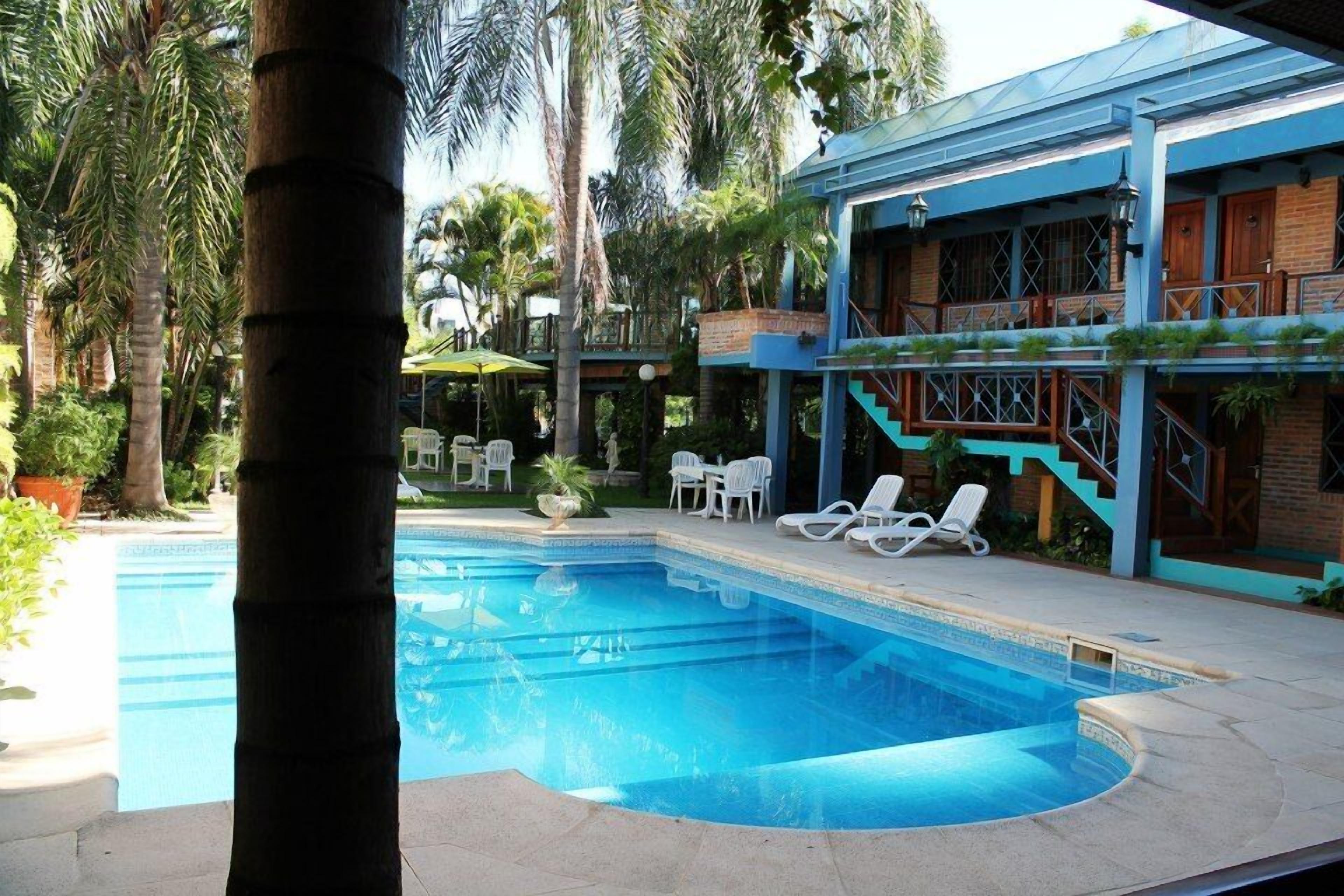 A swimming pool with lounge chairs and a building with a blue facade.