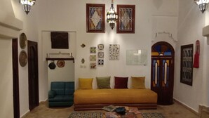 A living room with a sofa, coffee table, and decorative wall art. - Dar Rehla (Tetouan)