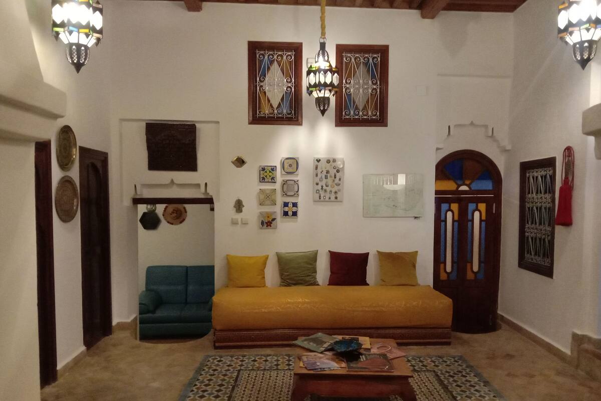 A living room with a sofa, coffee table, and decorative wall art.